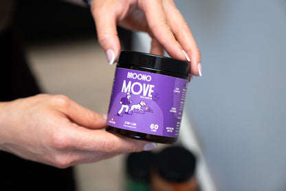 Person holding a purple jar labeled 'Broono Move' with a blurred background