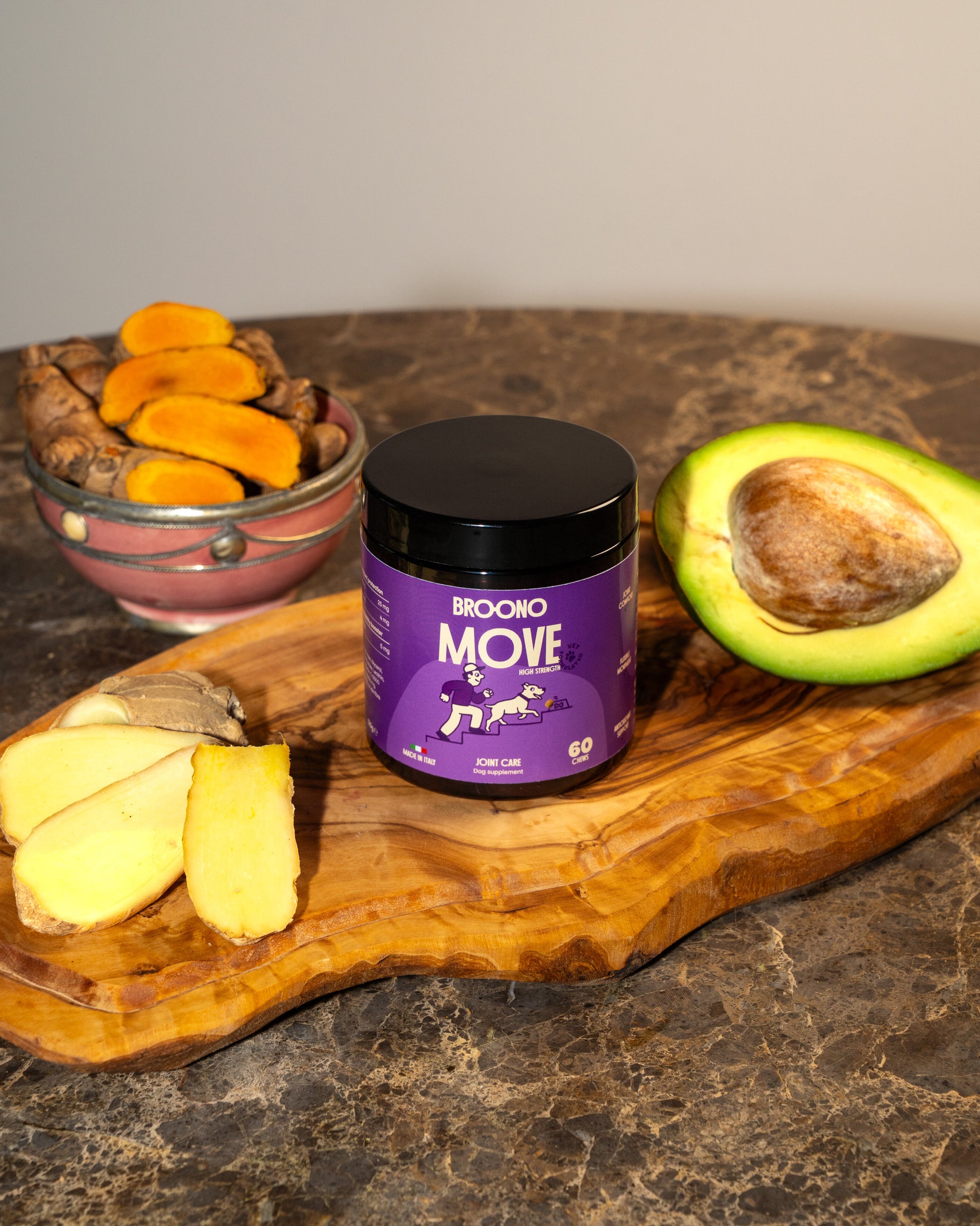 Broono Move jar on a wooden board with turmeric and an avocado.